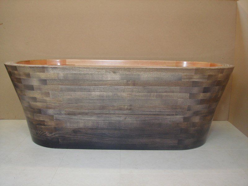 A wooden bathtub is sitting on top of a white table.