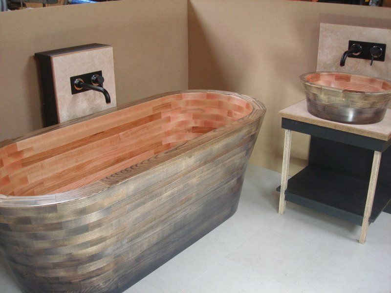 A bathroom with a wooden bathtub and a sink