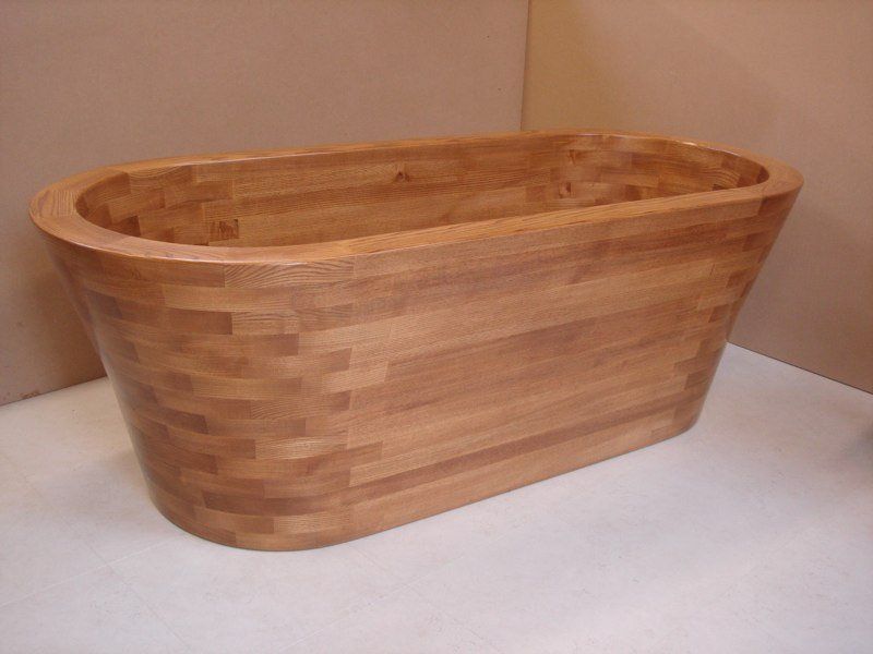 A wooden bathtub is sitting on a white surface.