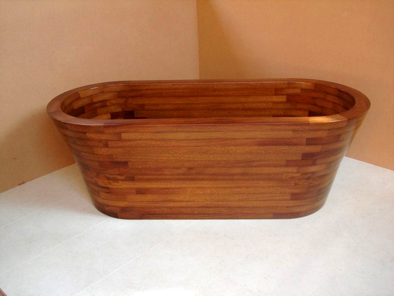 A wooden bathtub is sitting in a corner of a bathroom