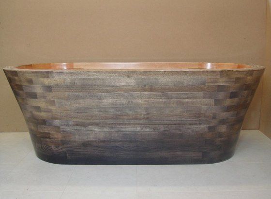 A wooden bathtub is sitting on top of a white table.