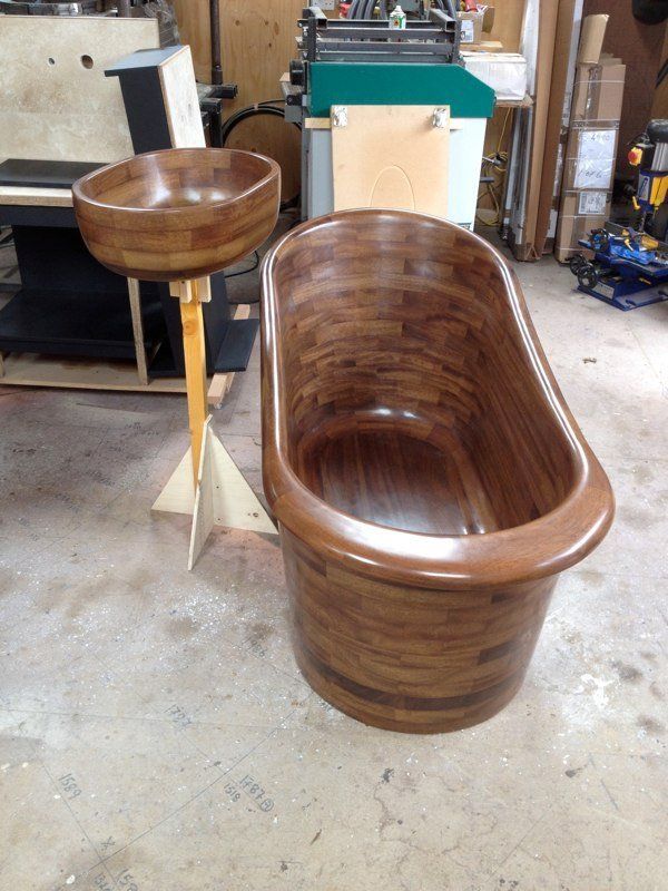 A wooden bathtub sits next to a wooden sink