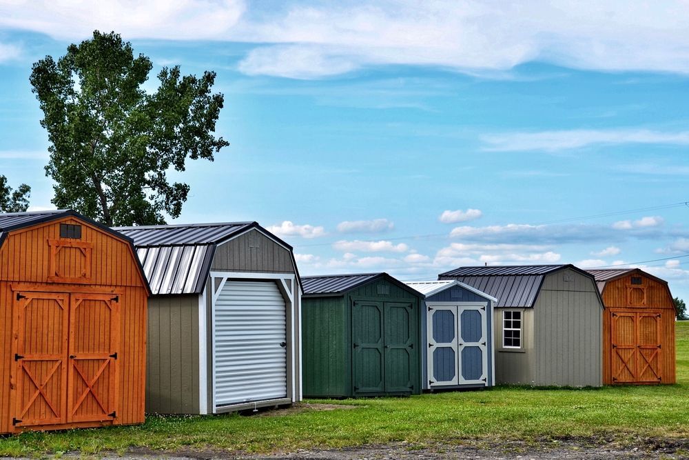 Row of Colorful Storage Sheds on a Grassy Field — ShedBoss in Atherton, QLD