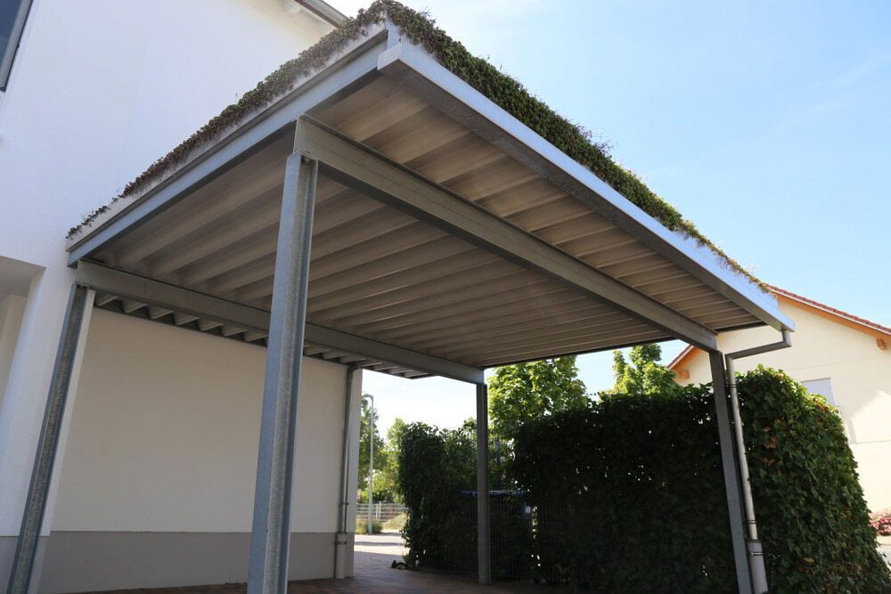 Metal Carport With a Green Roof, Attached to a White Building — ShedBoss in Malanda, QLD
