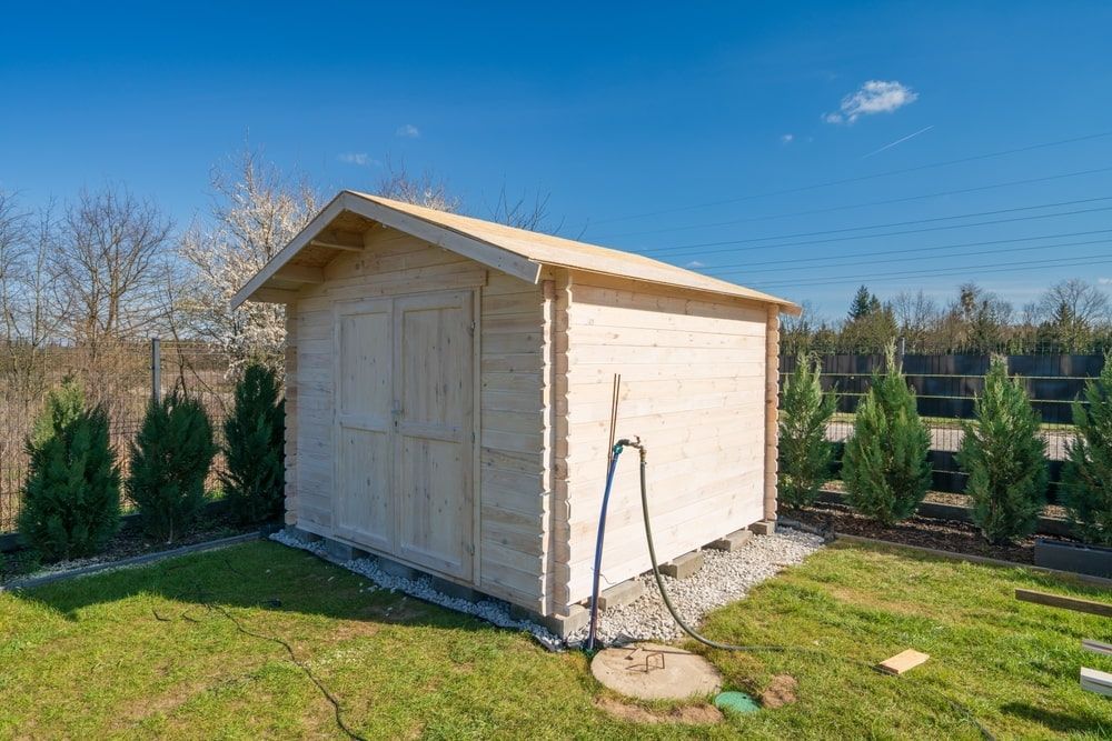 Wooden Shed With a Pitched Roof on a Grassy Lawn Under a Blue Sky — ShedBoss in Millaa Millaa, QLD