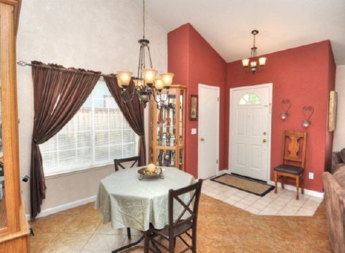 A dining room with a table and chairs and a chandelier