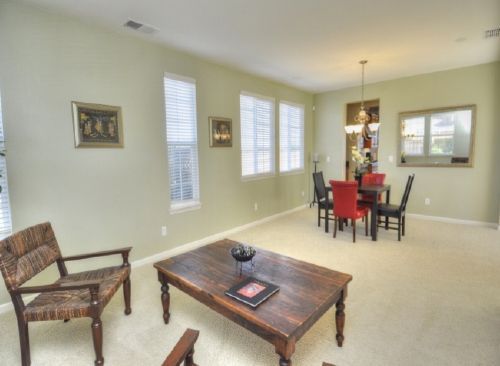 A living room with a wooden table and chairs