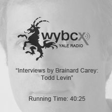 A black and white photo of a man with a goat on his head.