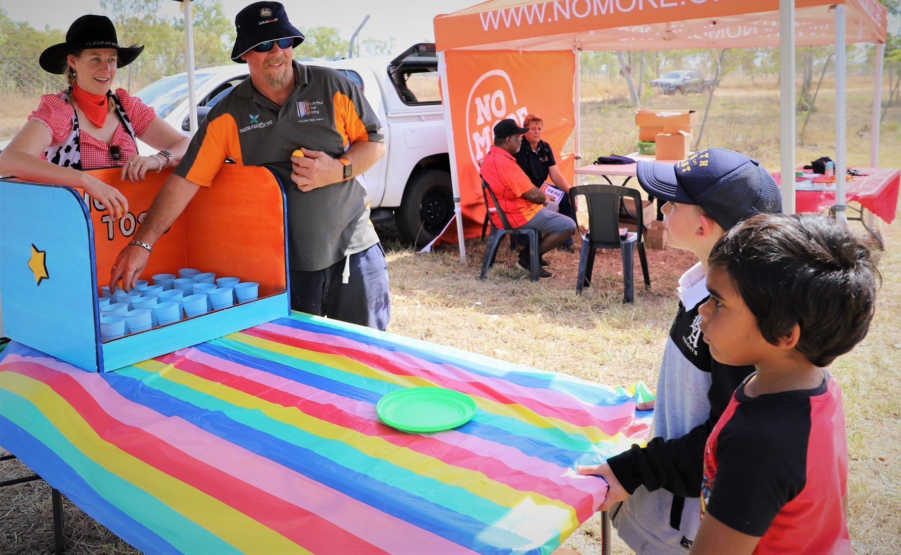 A group of people are playing a game with a rainbow table cloth.
