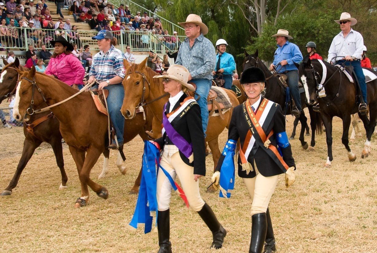 A group of people riding horses in a field