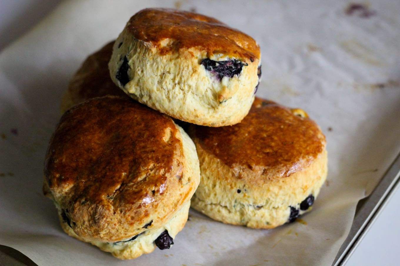 Three scones are stacked on top of each other on a piece of wax paper.