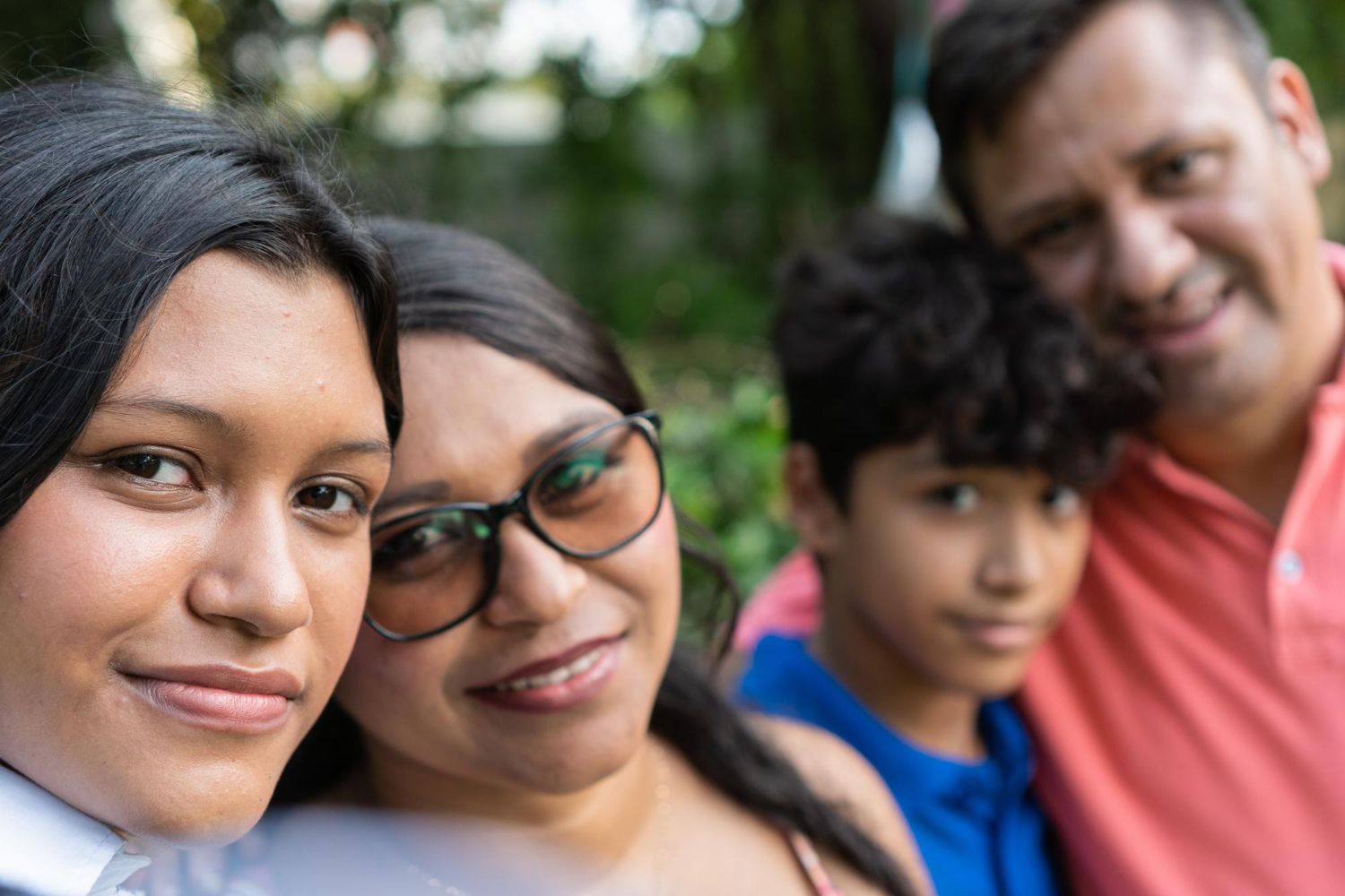 A family is posing for a picture together in a park.