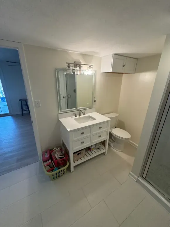 A bathroom with a sink , toilet and mirror.