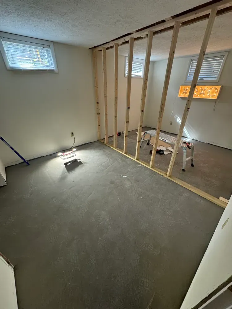 A room with a wooden frame on the wall and a concrete floor.