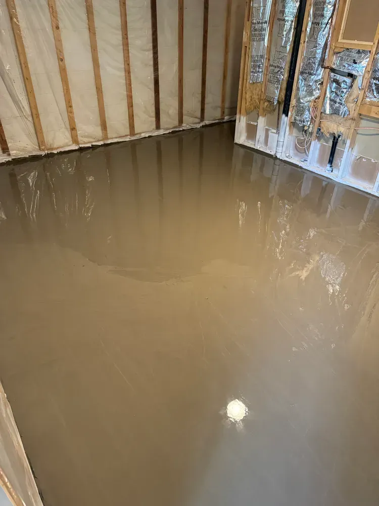 A room with a concrete floor and a wooden wall.