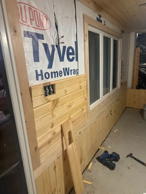 A wooden wall with a window and a sign that says tyvel home wrap.