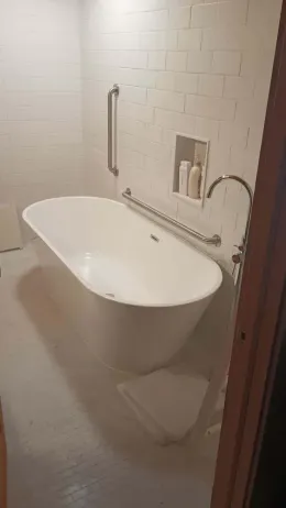 A bathtub is sitting in a bathroom next to a door.