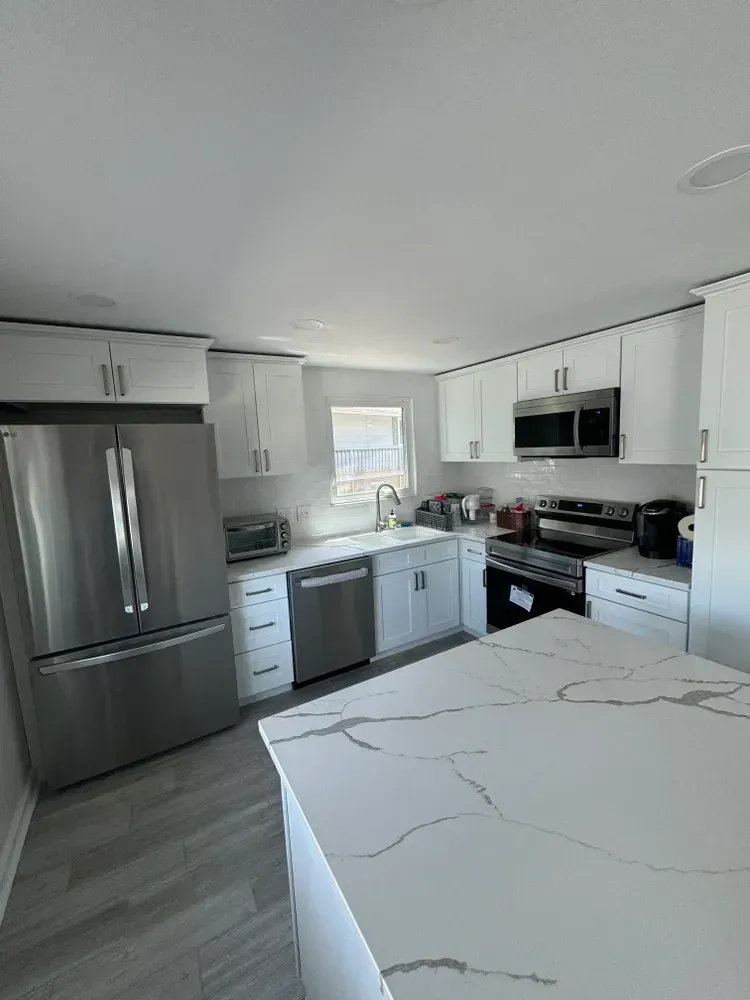 A kitchen with stainless steel appliances and white cabinets.