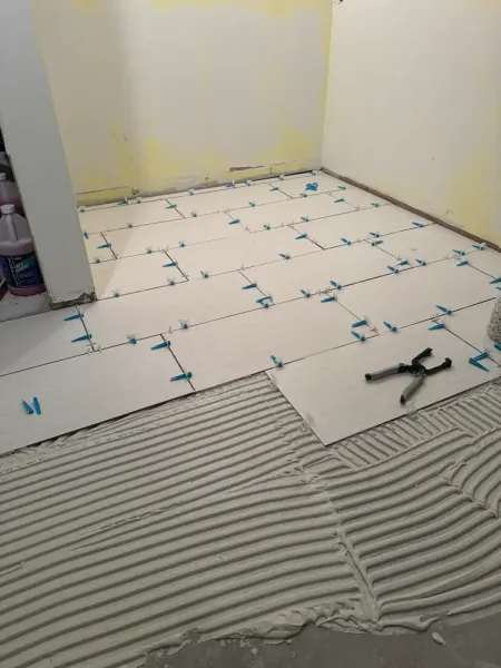 A tile floor is being installed in a room.