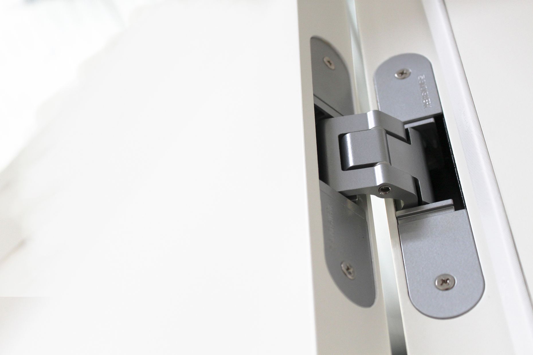 Un gros plan d'une charnière de porte sur une porte blanche