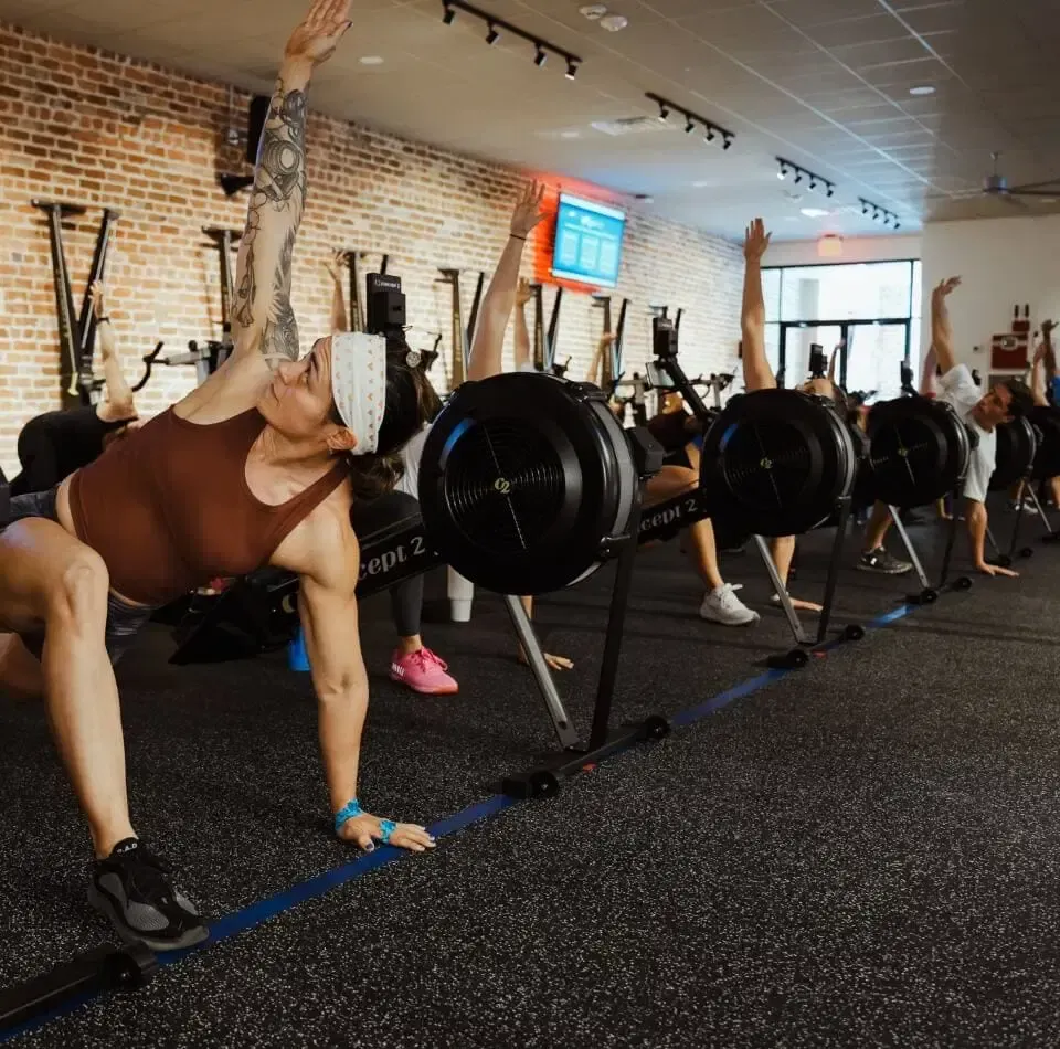 People in a gym in New Orleans performing rowing exercises on rowing machines.