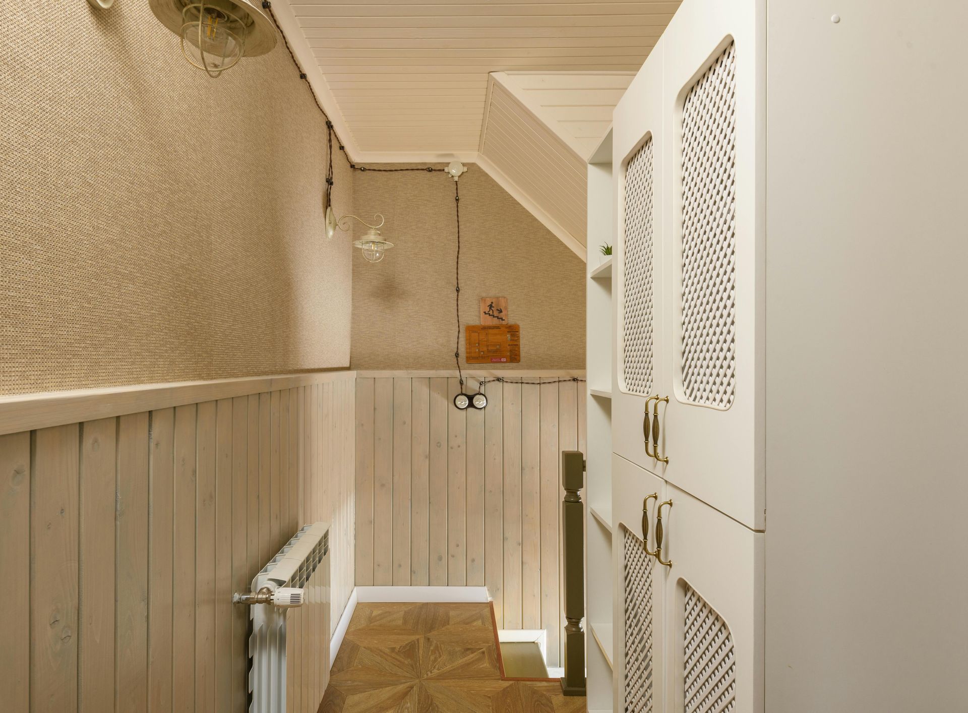 Couple sitting amongst moving boxes, man pointing, woman looking up. Interior, light-colored walls.