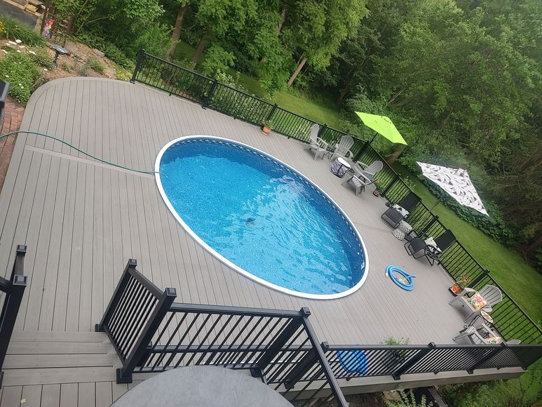 An aerial view of a large oval swimming pool on a deck.