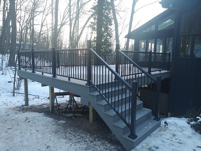 A deck with stairs leading up to it in the snow