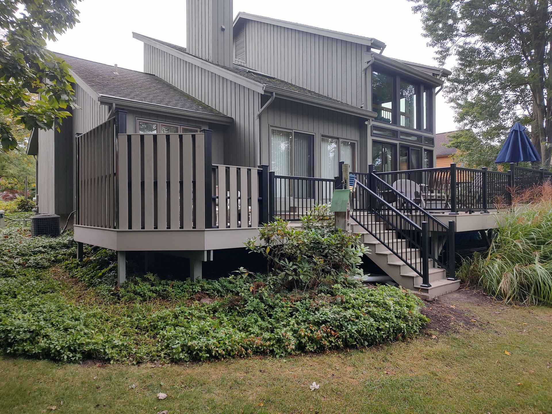 A large house with a large deck and stairs leading up to it.