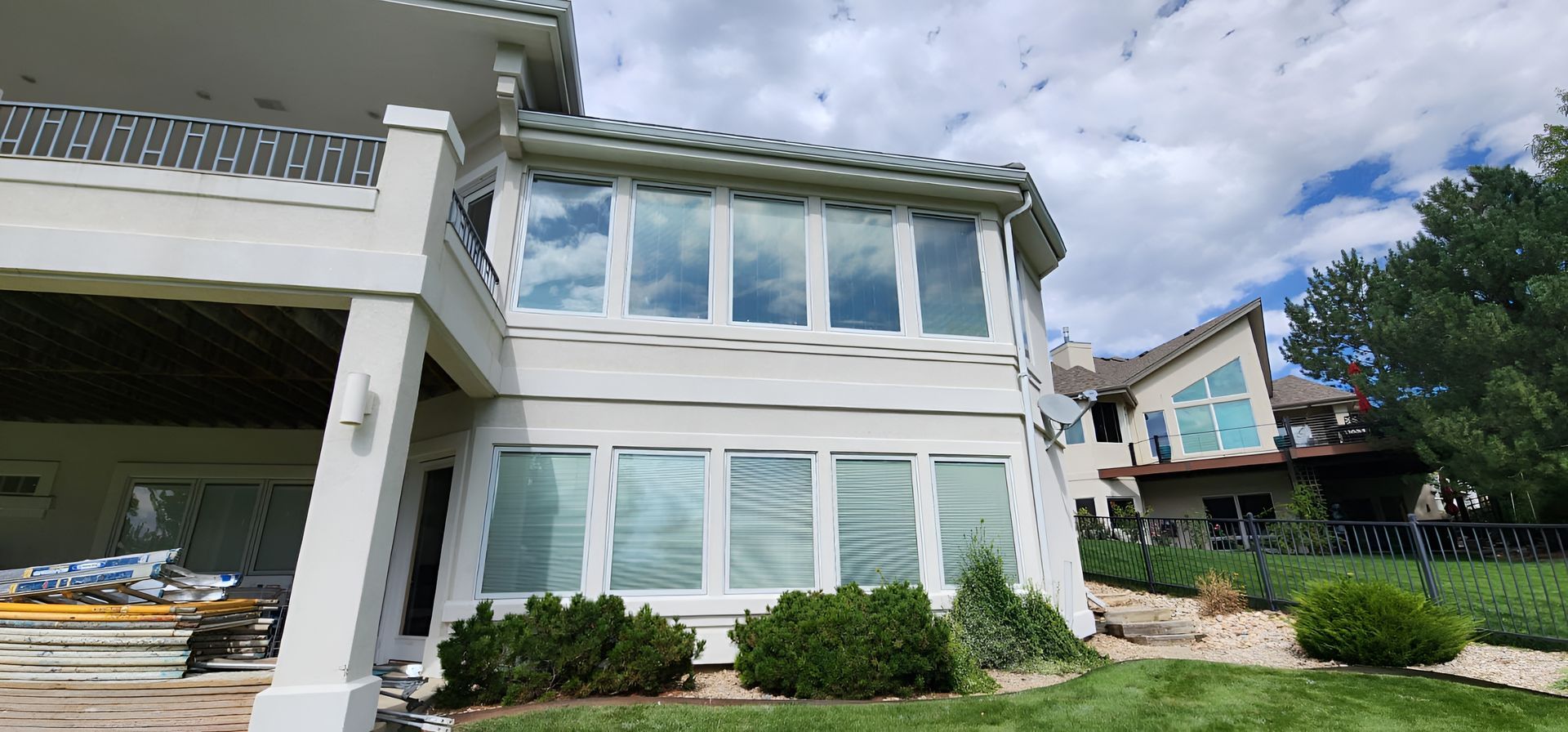 Exterior view of a multi-story white house with many windows and a grassy yard.