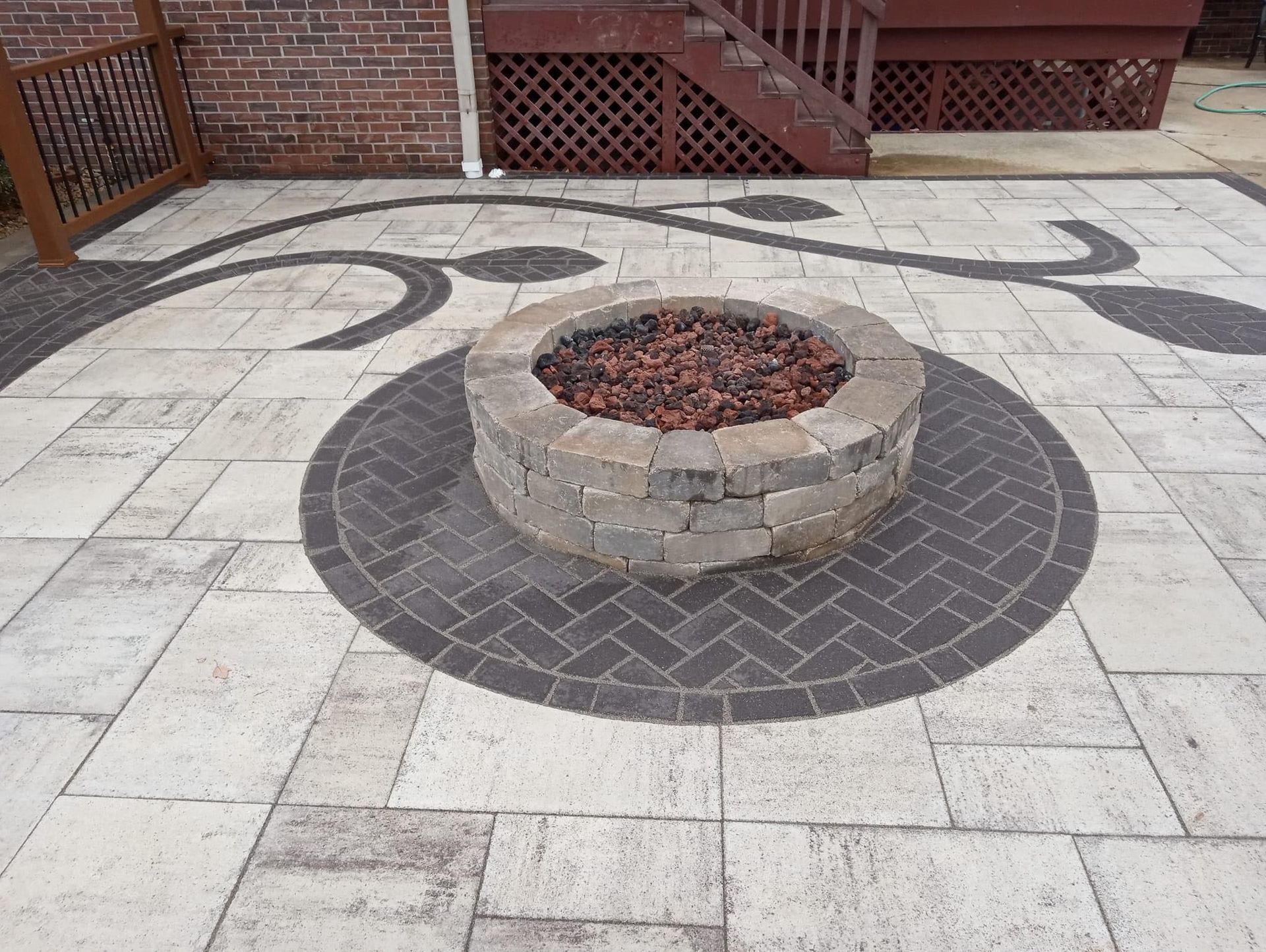 Patio with brick fire pit and decorative stone pavers.