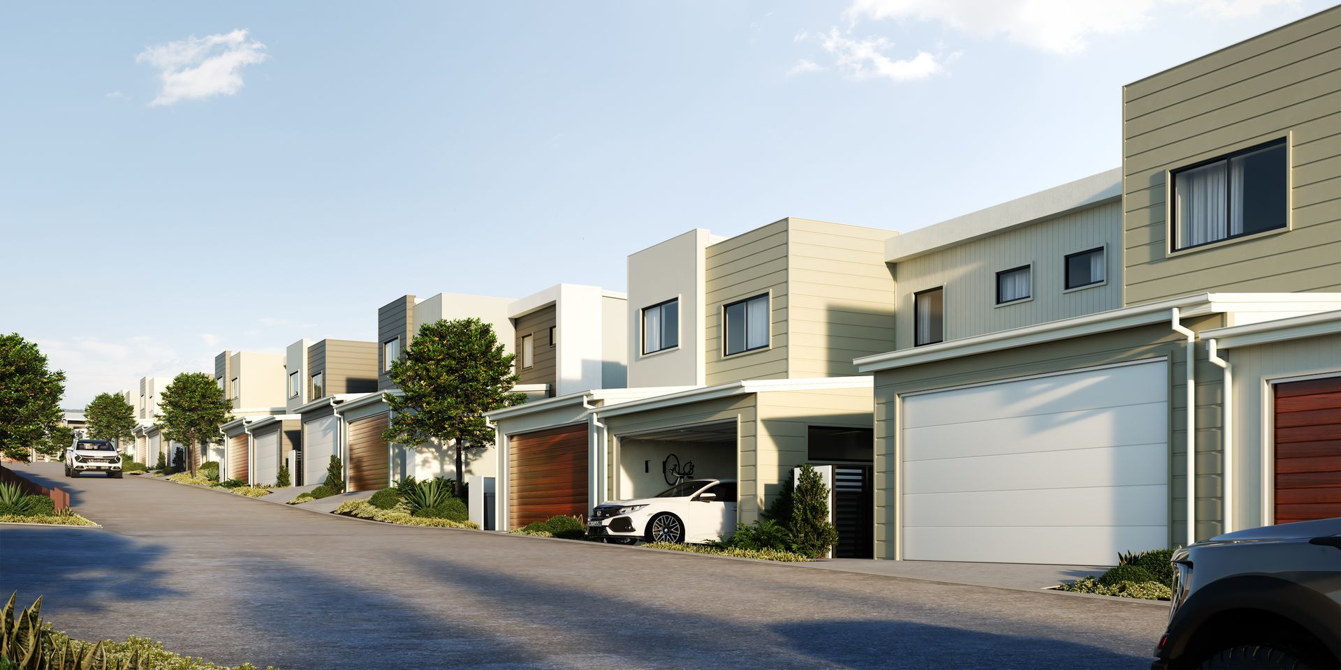 Row of modern townhouses on a street, some with open garages, blue sky overhead.