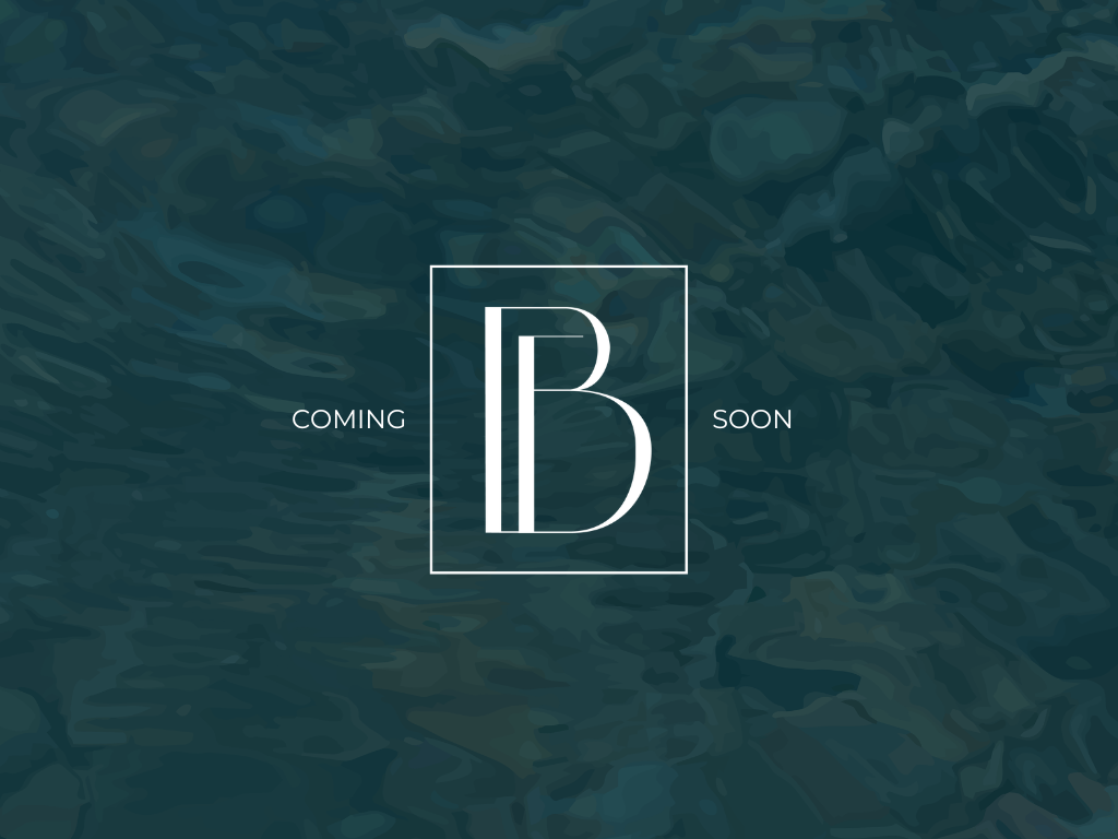 Aerial view of a vacant grassy lot outlined in red, surrounded by houses and greenery near a road.