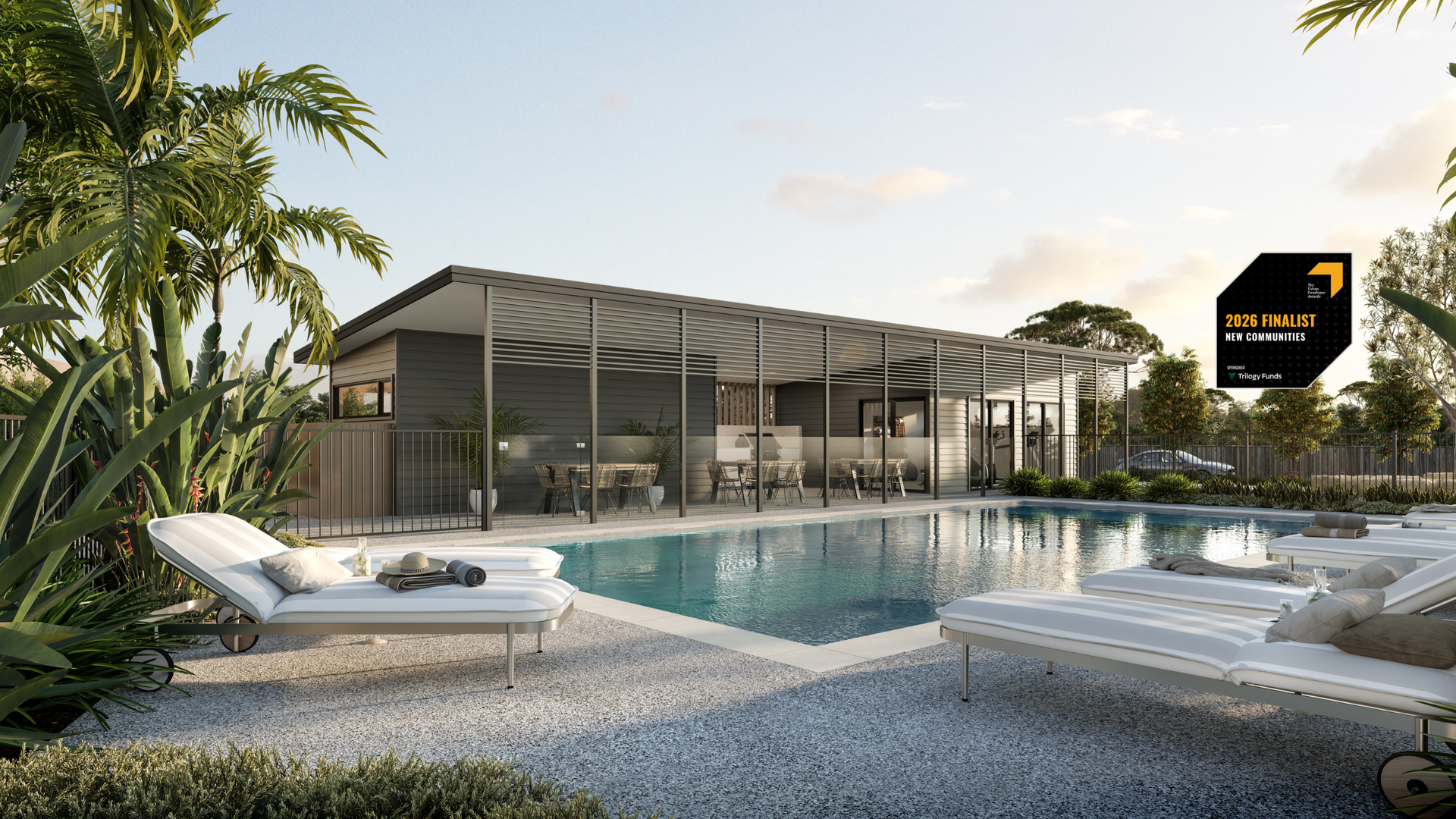 Swimming pool with lounge chairs, building with a covered outdoor area, and palm trees.