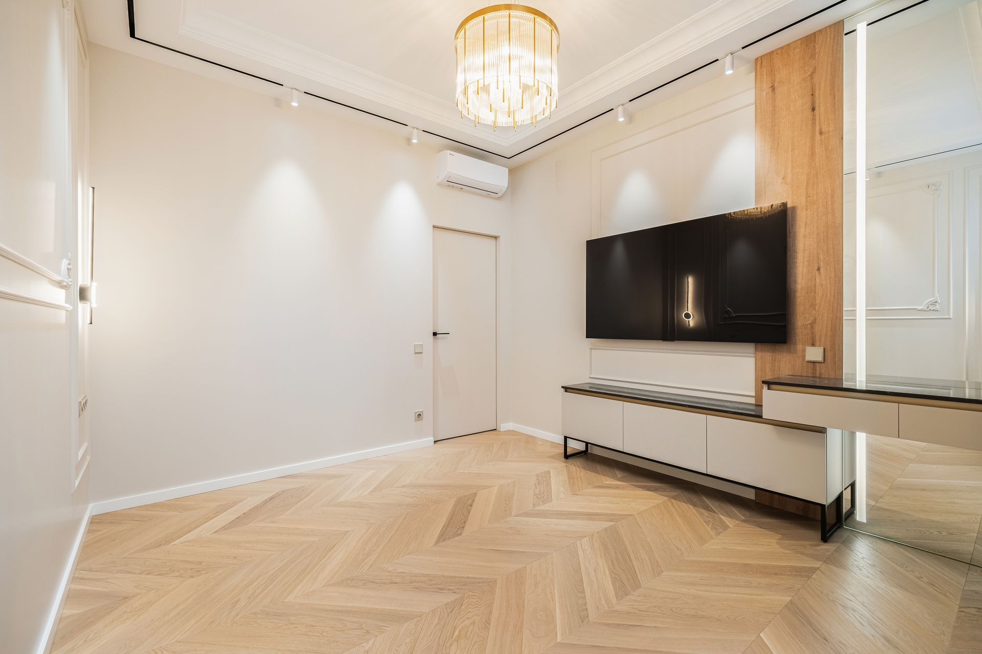 Dark wood-look flooring under a white table in a room with white walls.