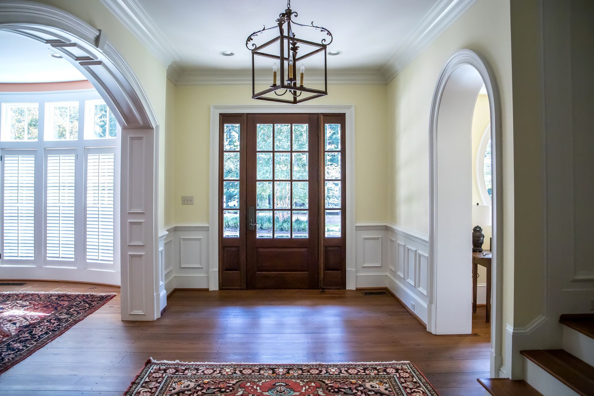 Wooden entryway with a dark brown door, cream walls, and wood floors.