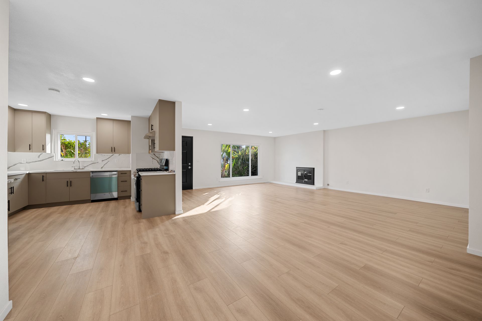 Fireplace with light-colored stone surround, wooden mantel, and a green candle, set against beige walls and tiled floor.