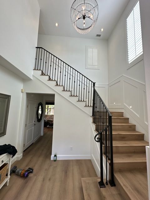 Interior view of a two-story home with a staircase, couch, and dark hardwood floor.