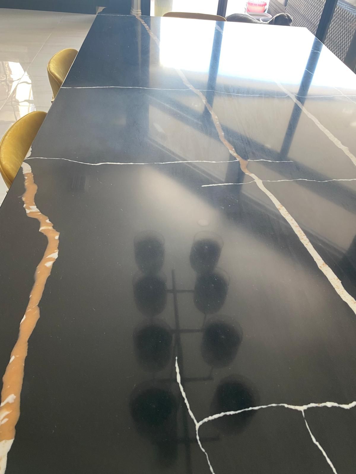 Black and gold veined table with reflections.