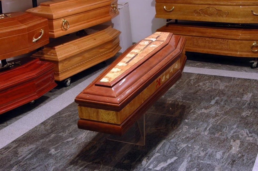 Incisione decorativa a croce su feretro in legno