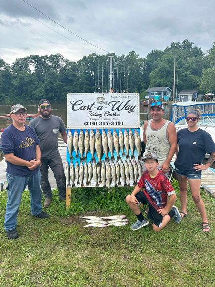 A group of people are standing in front of a sign with fish on it.