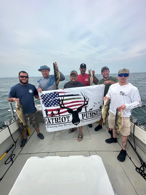 A group of men are standing on a boat holding fish and a flag.