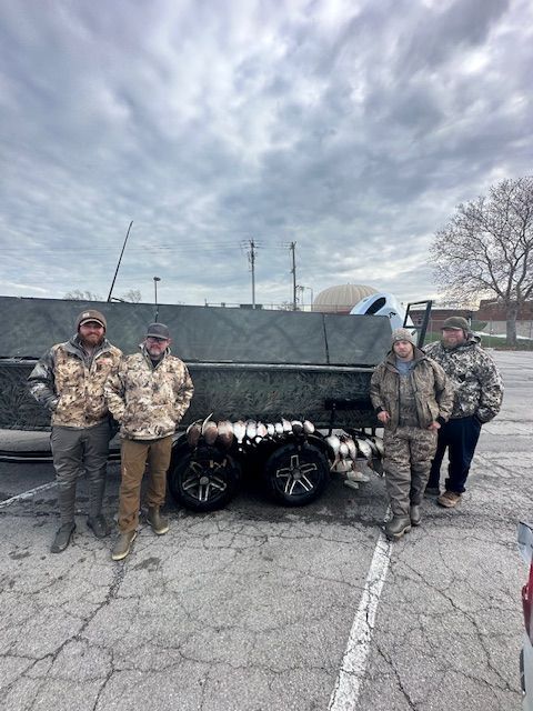 A group of men are standing next to a boat in a parking lot.