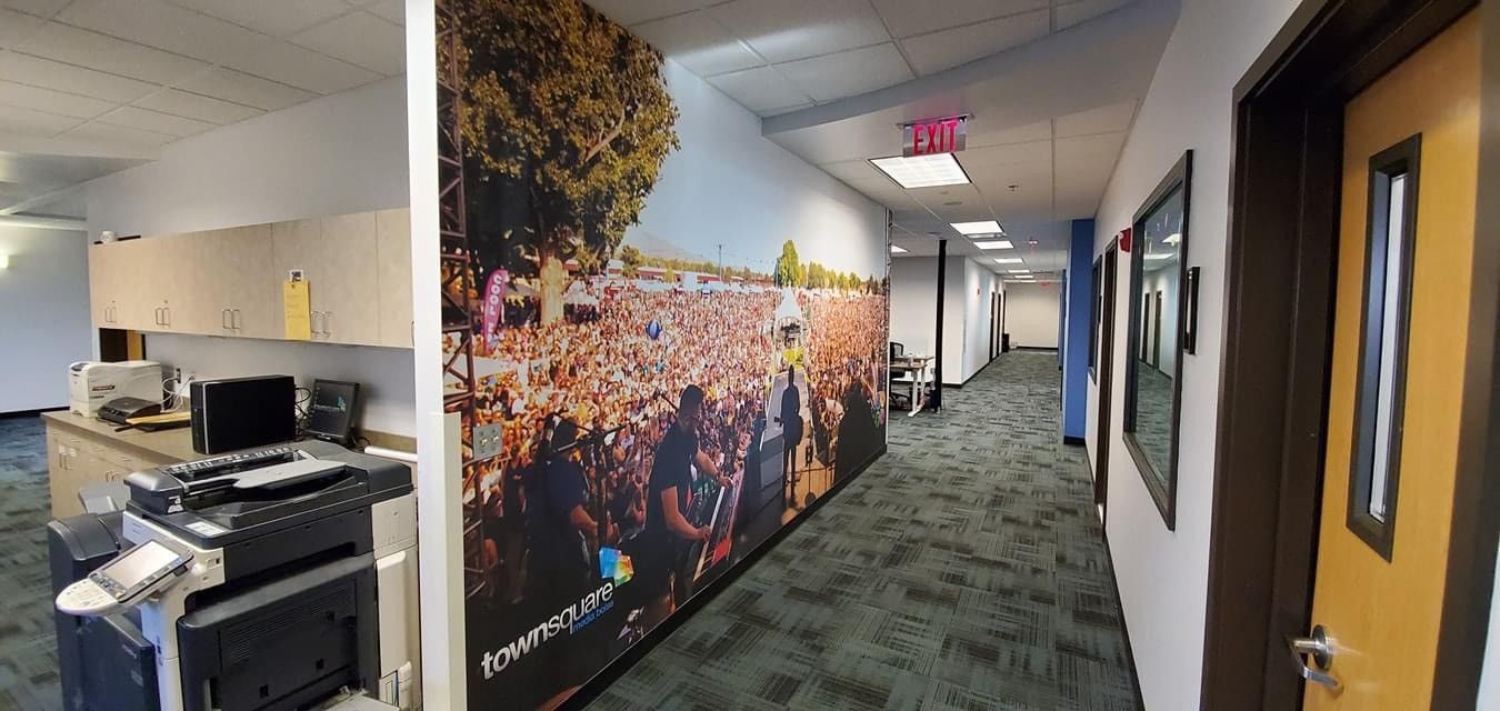 A hallway with a large picture on the wall and a door.