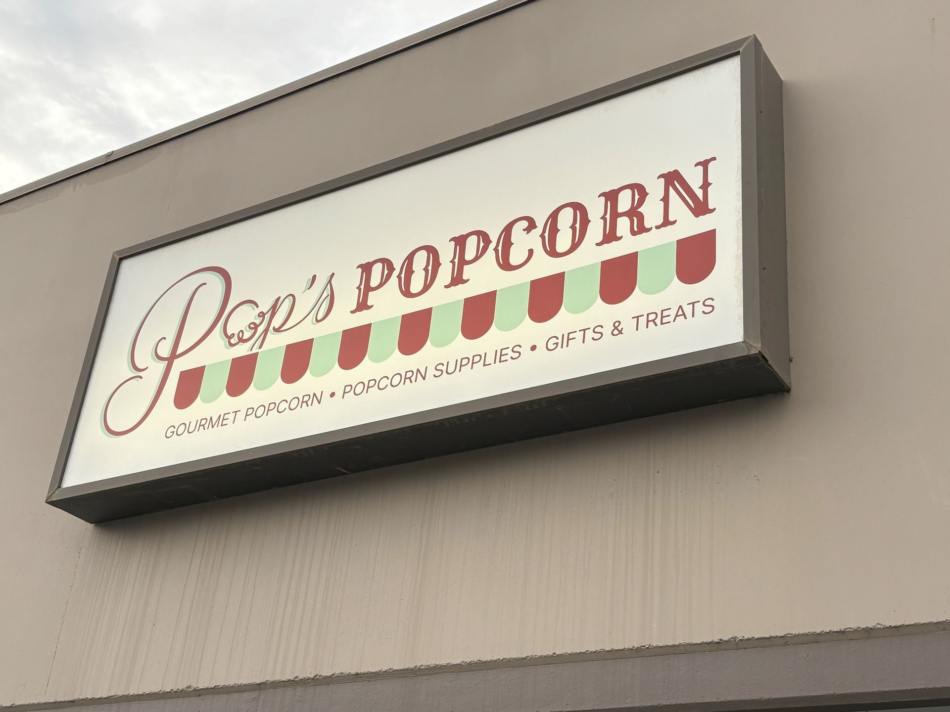 A sign for pop 's popcorn is on the side of a building.