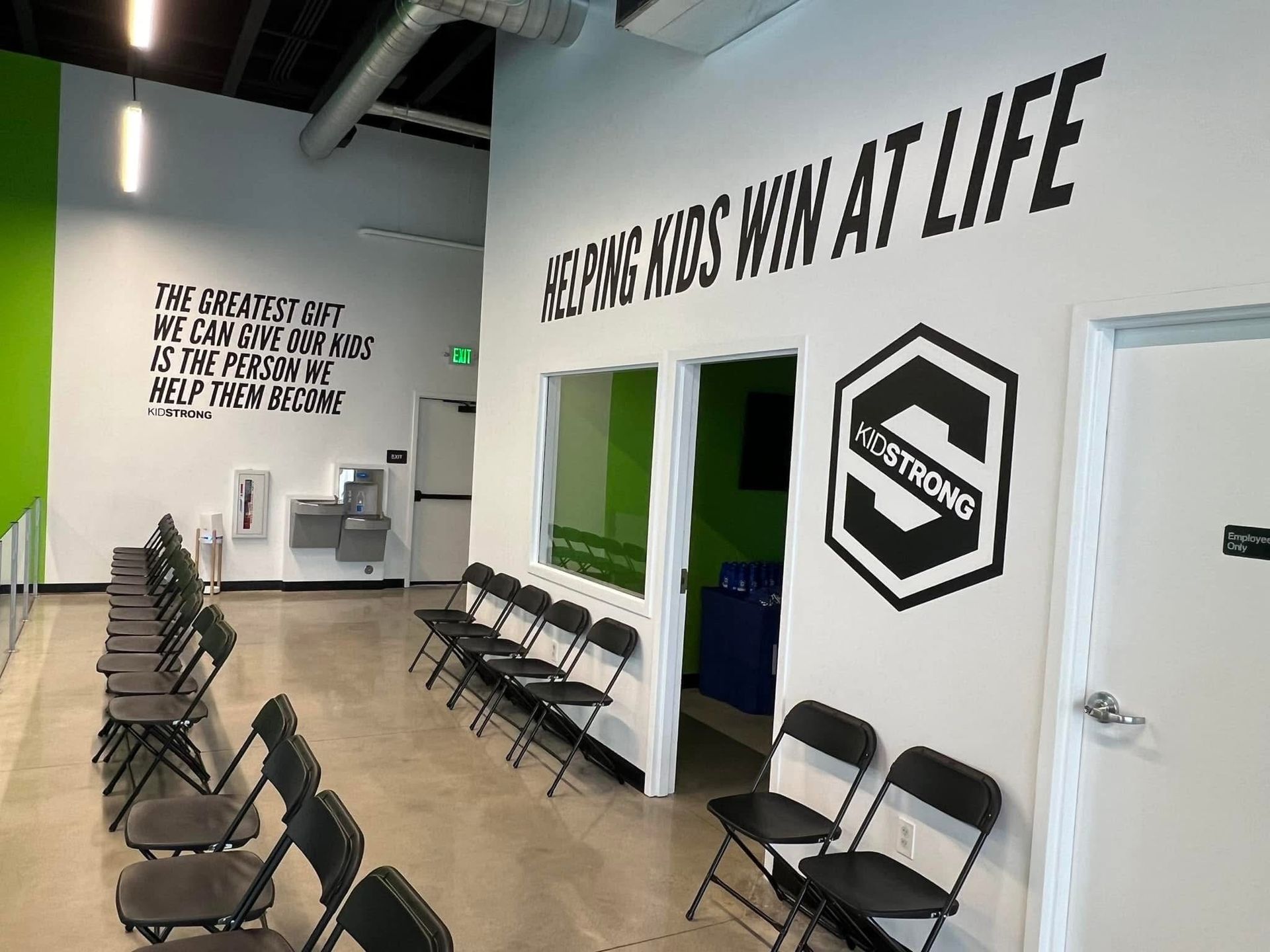 A waiting room with chairs and a sign that says ' helping kids win at life '