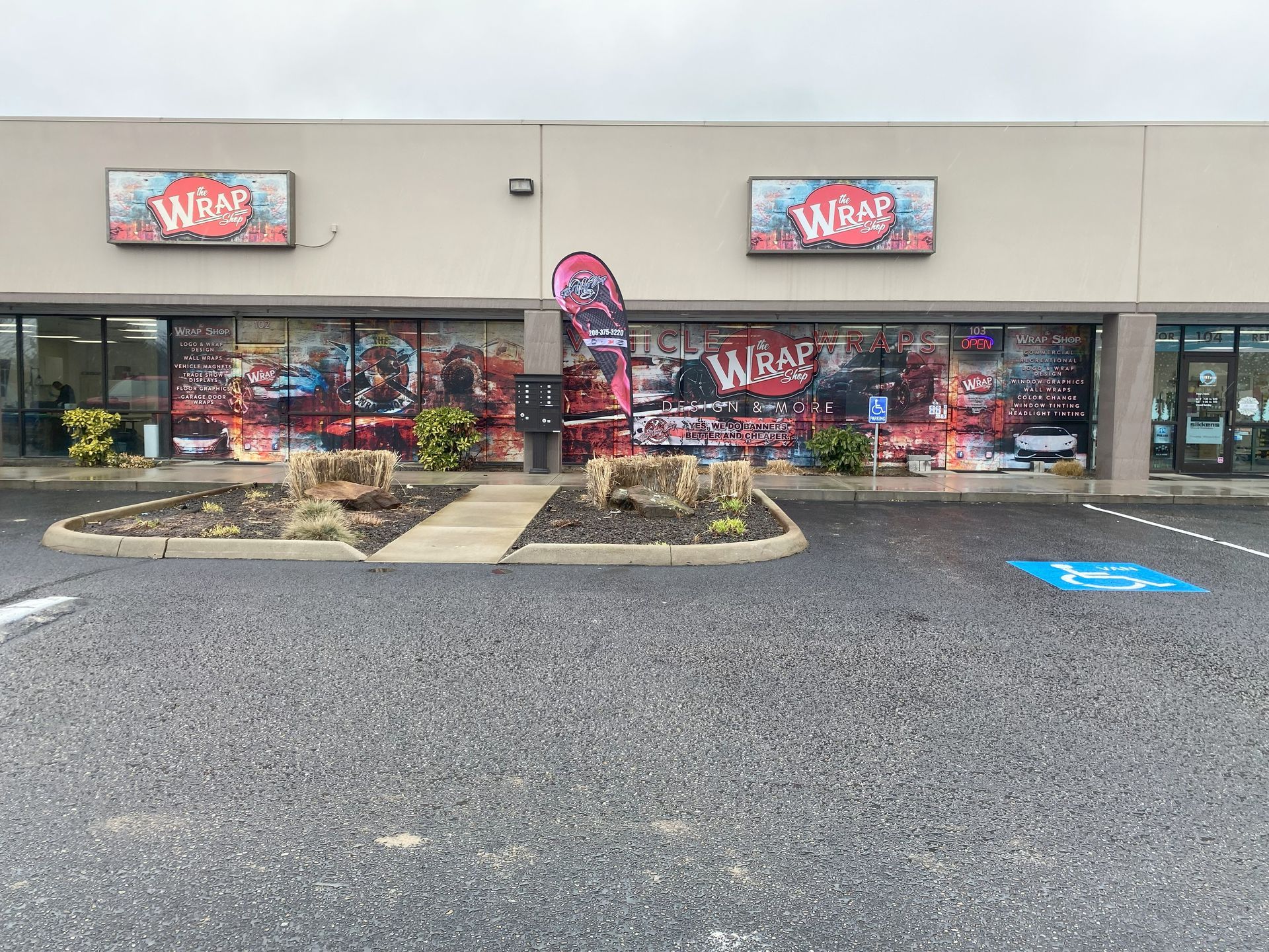 A store front with a handicapped parking spot in front of it.