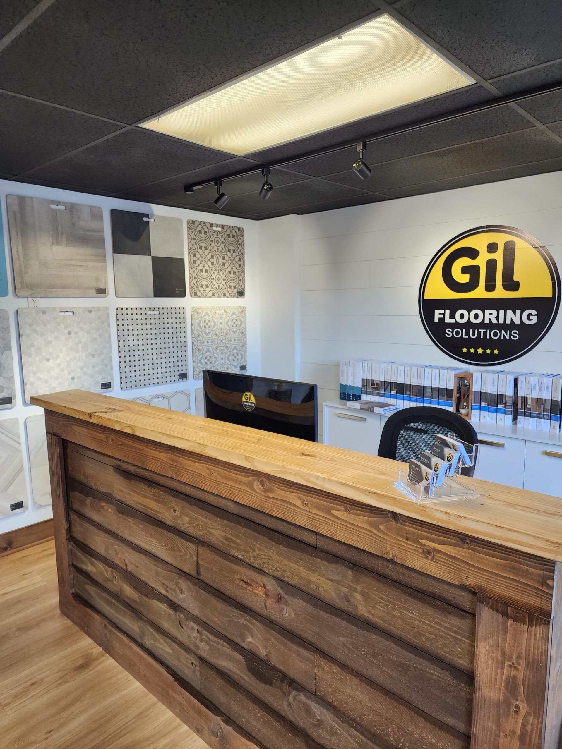 A wooden counter in a room with Gil Flooring sign