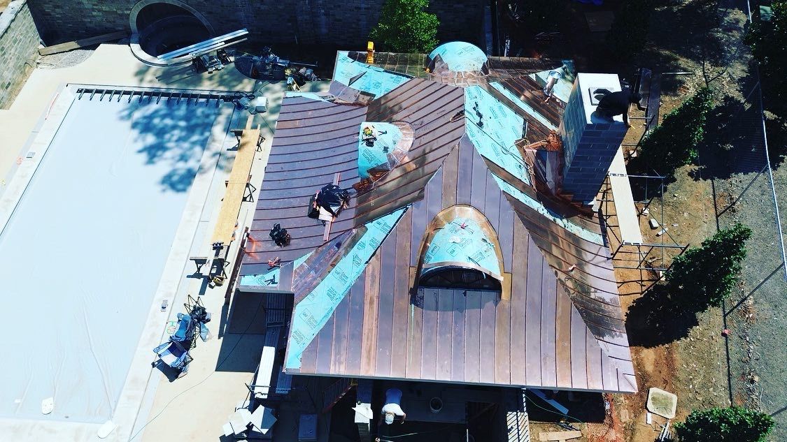 an aerial view of a house under construction with a pool in the background .