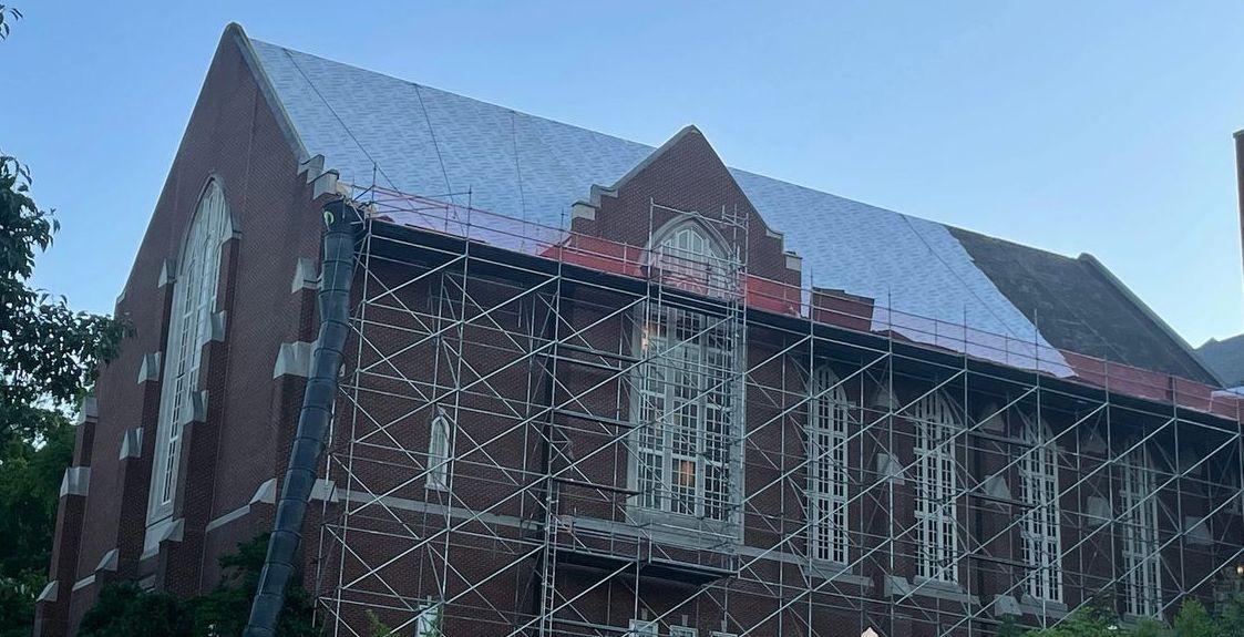 a large brick building with scaffolding around it is being remodeled .